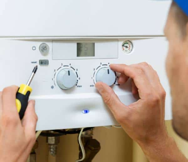 heating engineer adjusting settings on a boiler